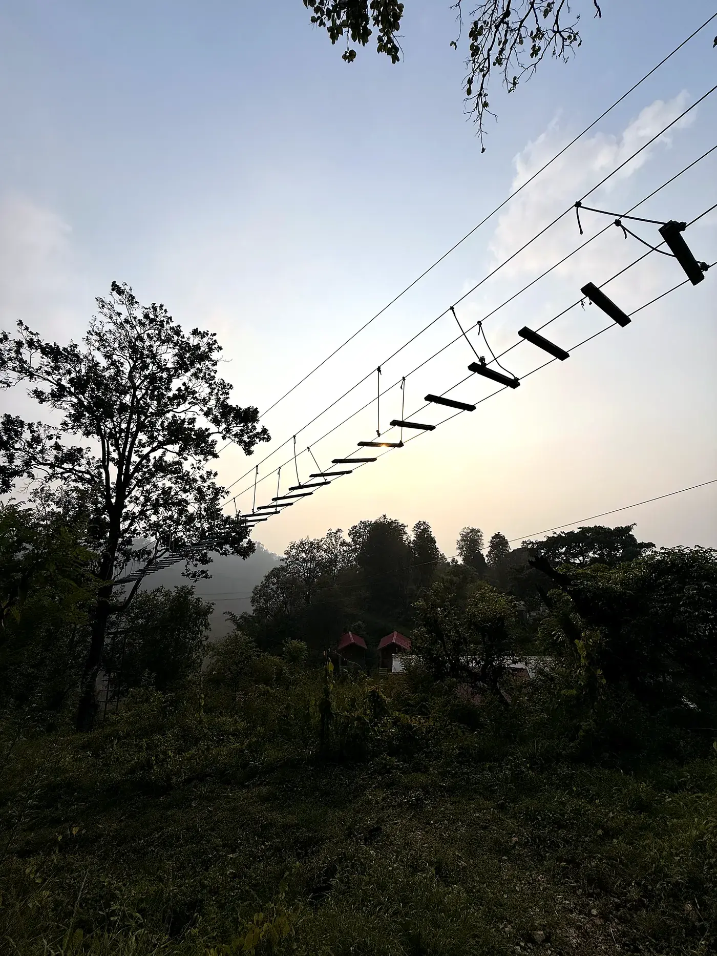 Rope bridge silhouetted at sunset